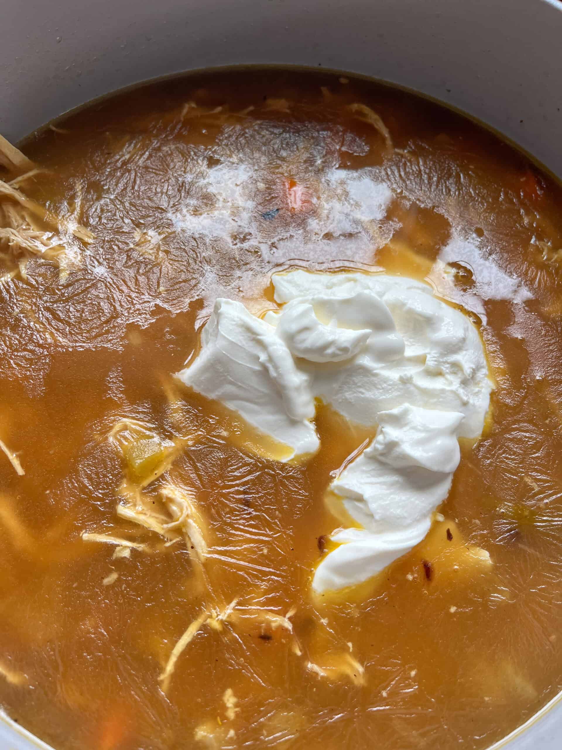 Adding sour cream to white chicken chili.