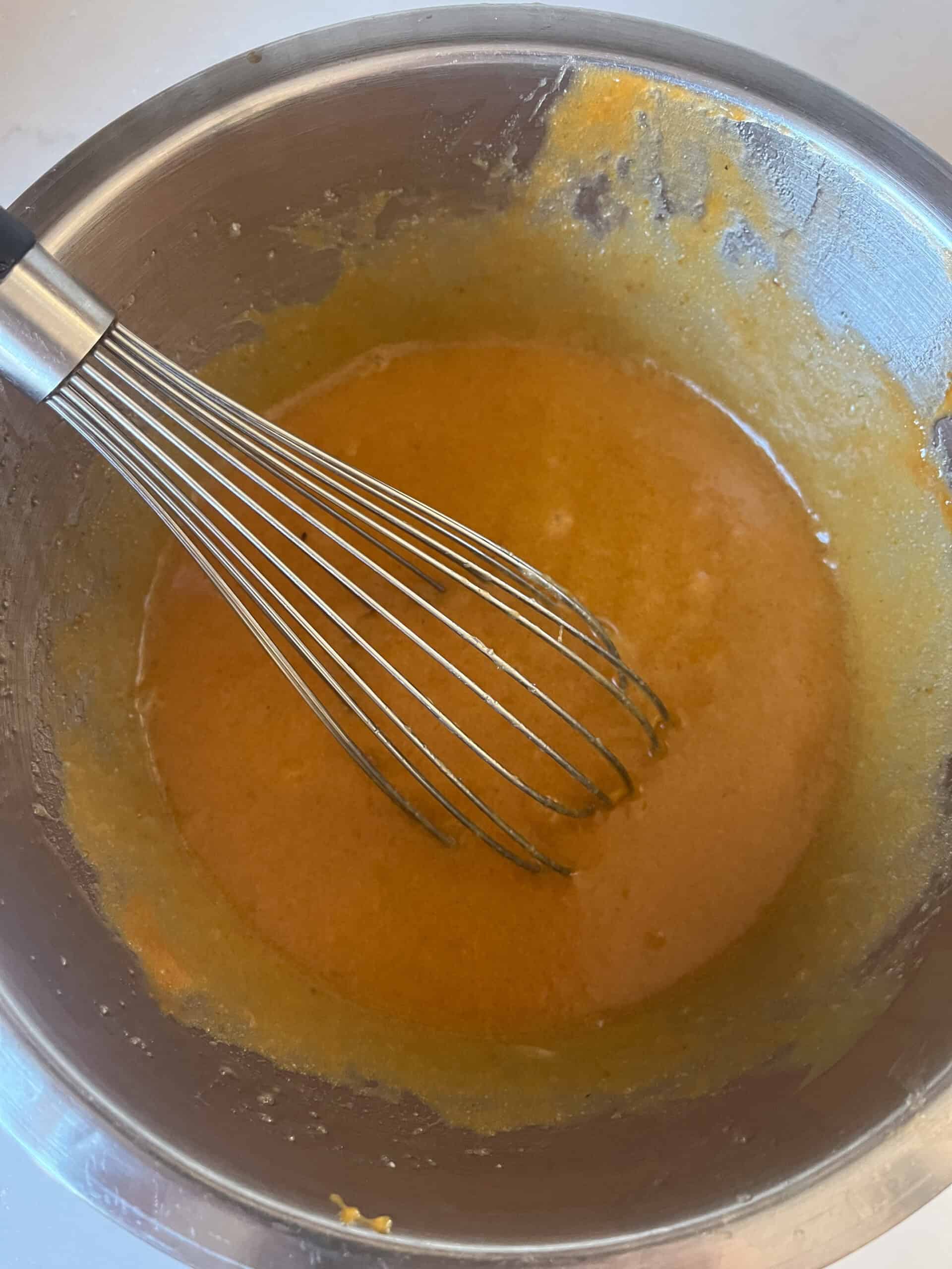 Whisking persimmon pulp and other wet ingredients.