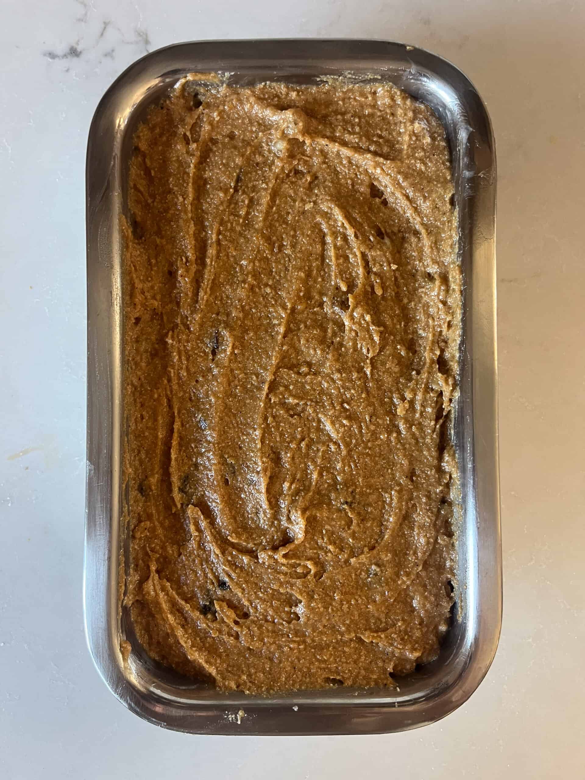 Spreading persimmon bread batter in a bread pan.