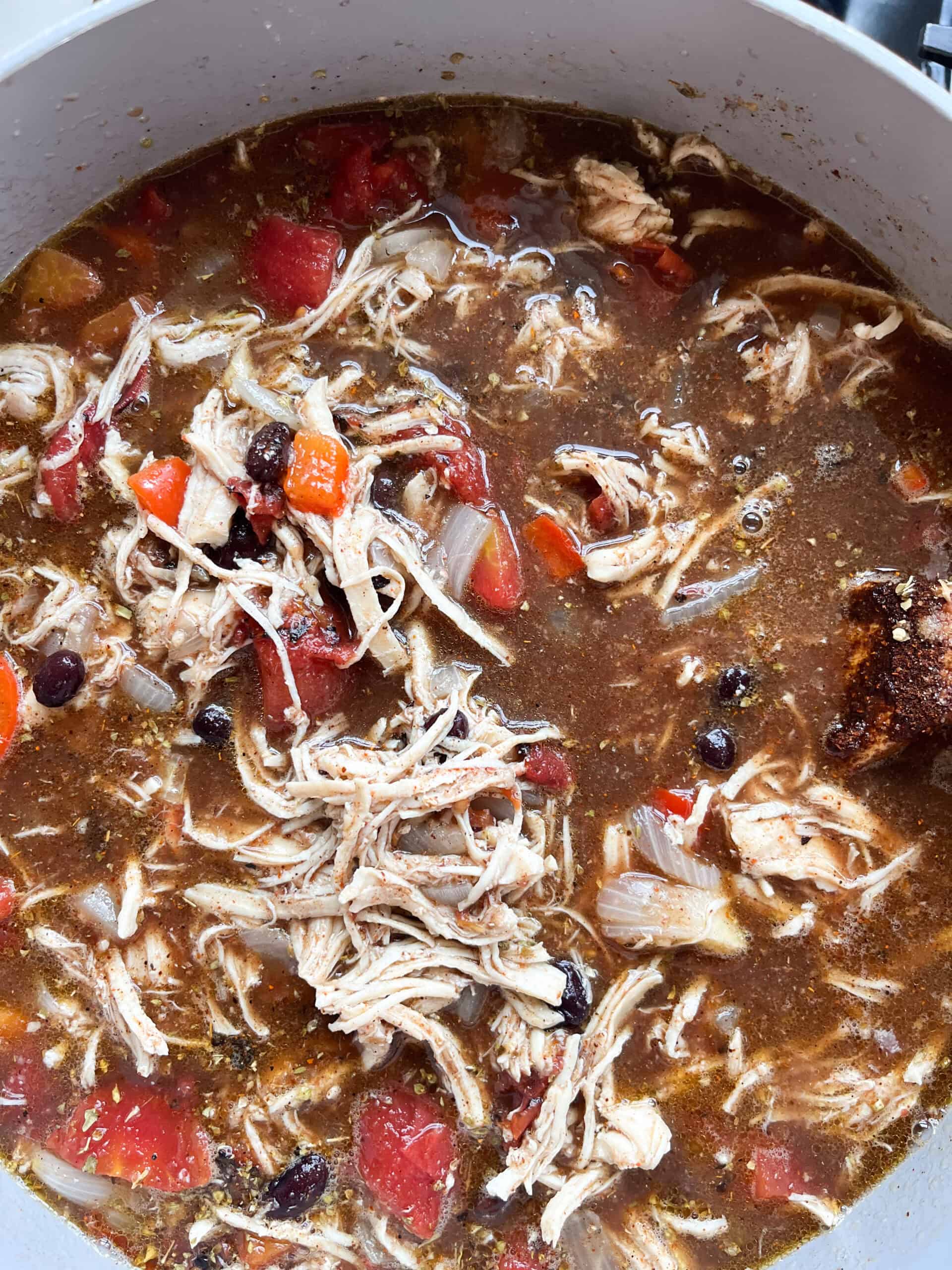 Adding broth and other ingredients to the pot.