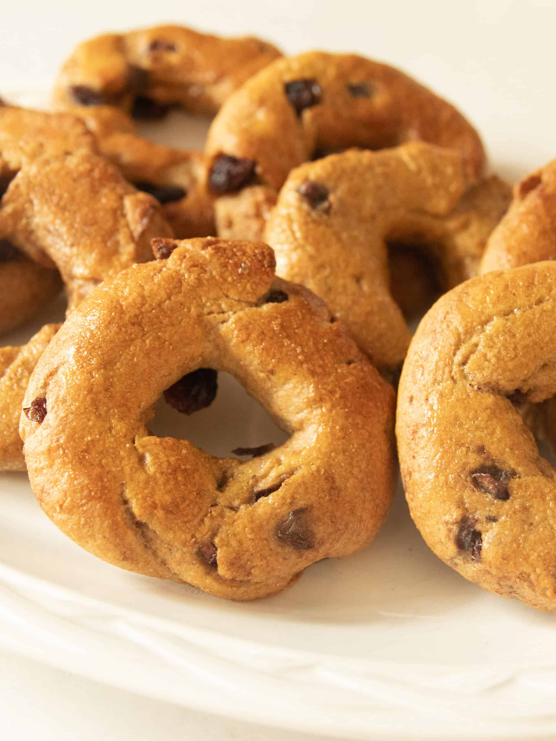 Cranberry bagels stacked on a white plate.